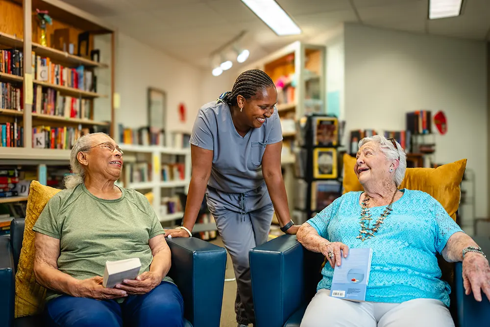 Two elderly people talking to a resource center staff person
