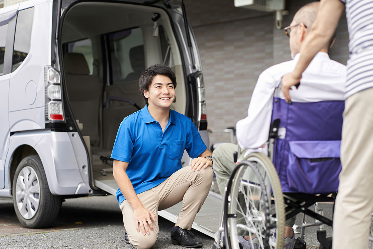 A-young-man-volunteer-engaging-with-a-older-man-in-a-wheelchair A-young-man-volunteer engaging with a older man in a wheelchair