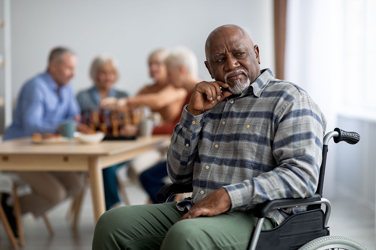 Man sitting in wheelchair looking contemplative