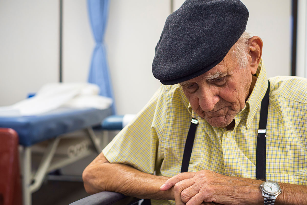 an elderly man looking down somewhat depressed maybe tired or lonely