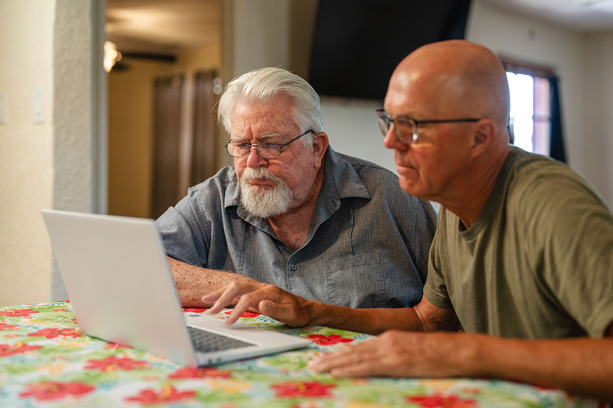 two gentlemen looking at something on a computer together