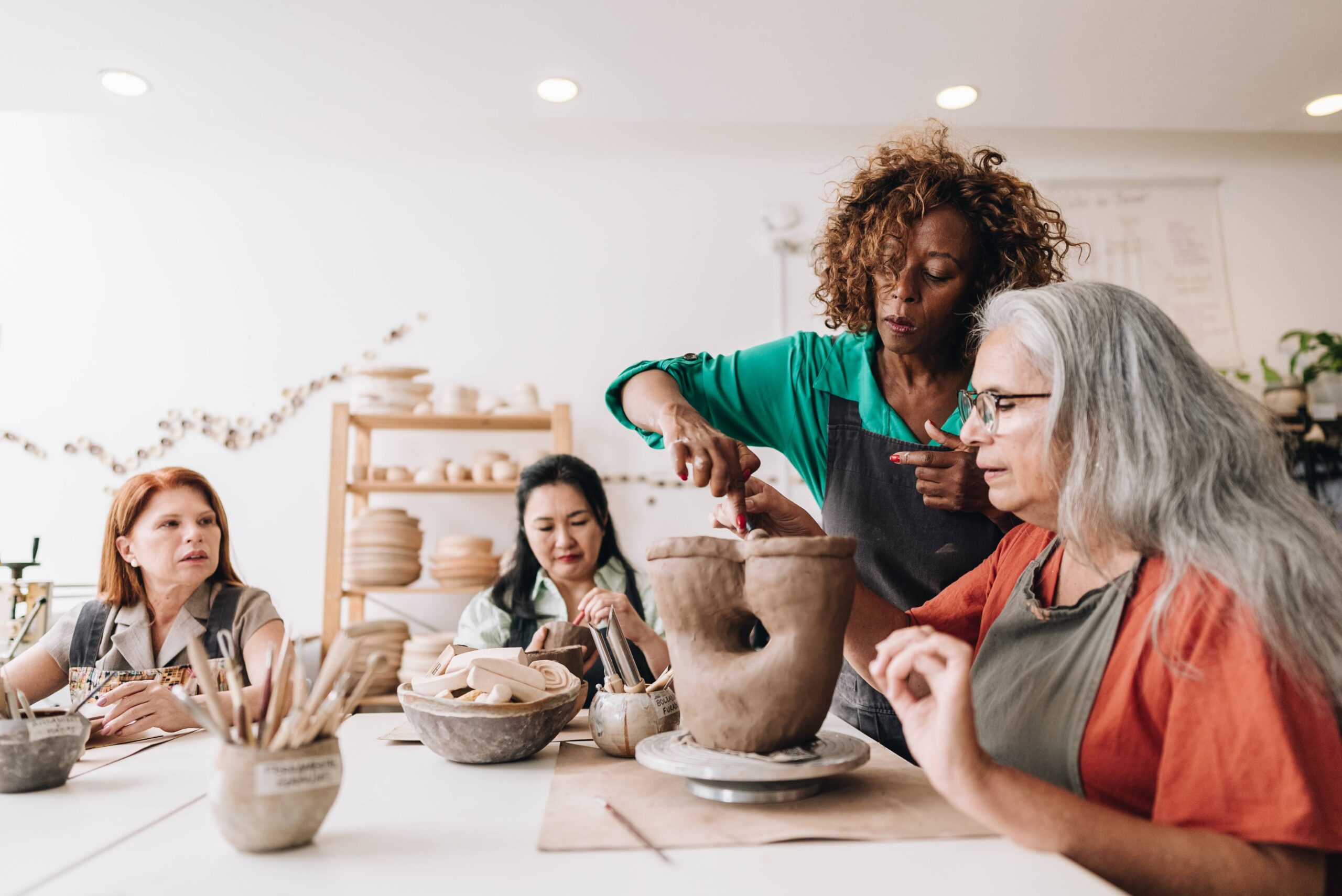Pottery teacher teaching her student at a ceramics workshop