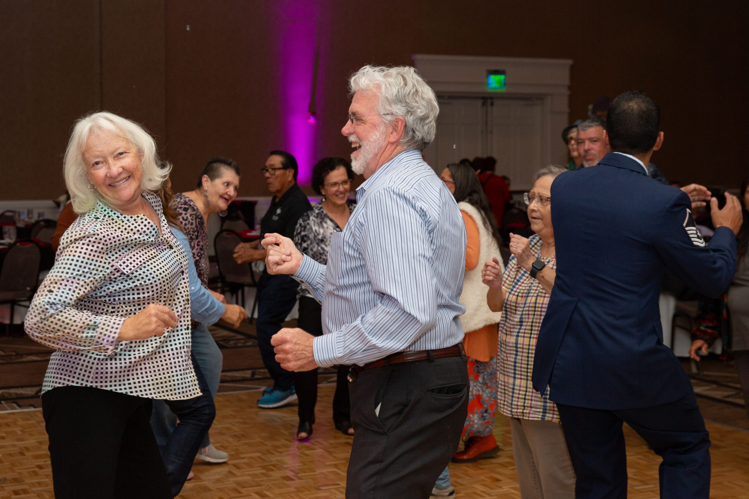An older couple dancing in a crowd enjoying themselves