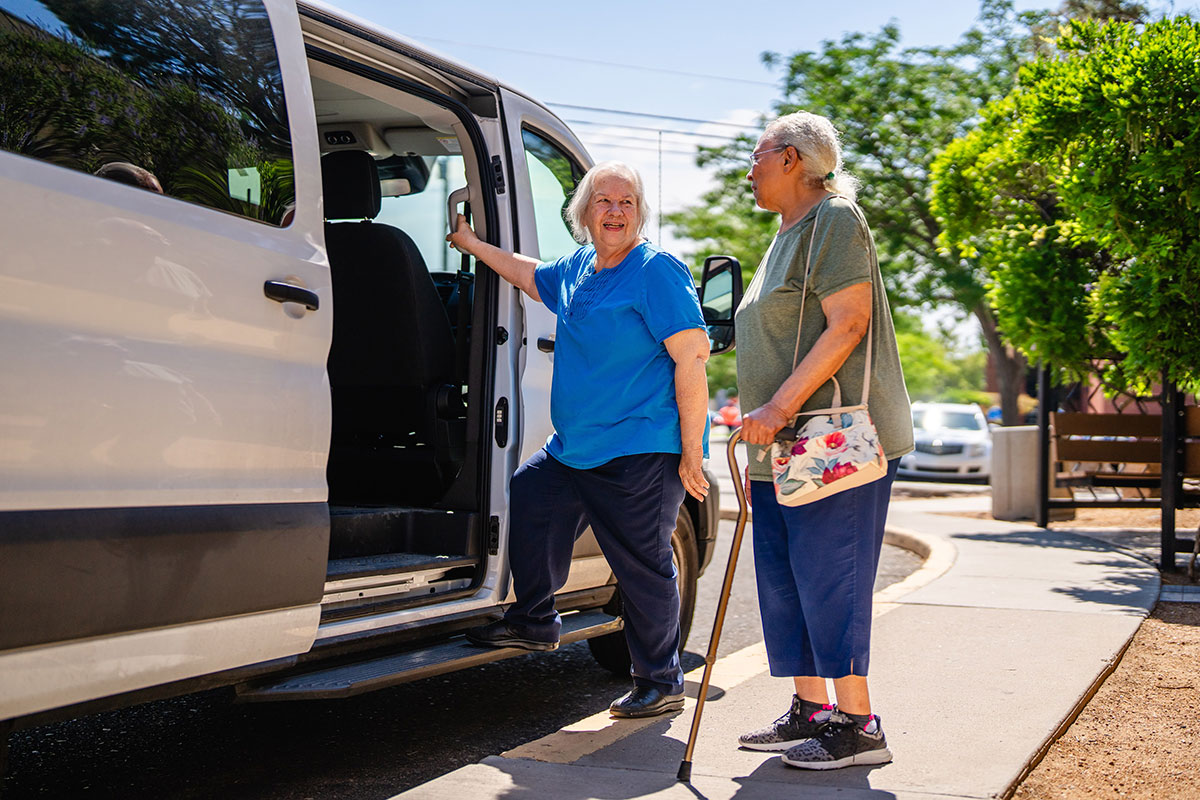 Two older women getting on an assisted transpot van.
