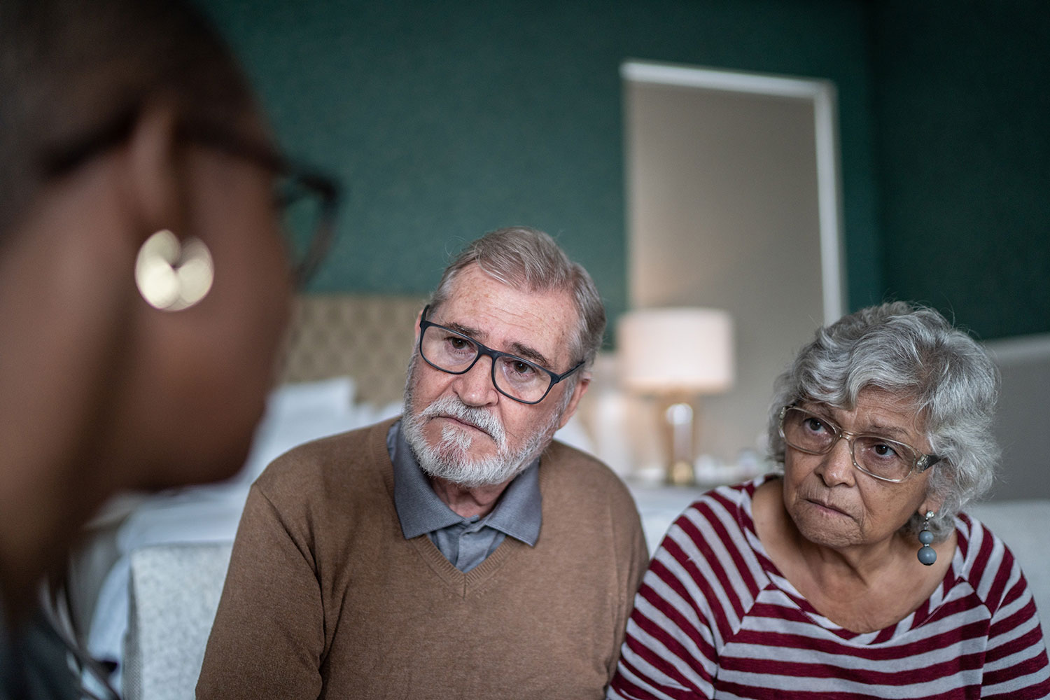 Two elderly persons on the left a man wearing glasses with a beard on the right a woman also wearing glasses with grey hair. Speak to a counselor that is a woman and person of color.